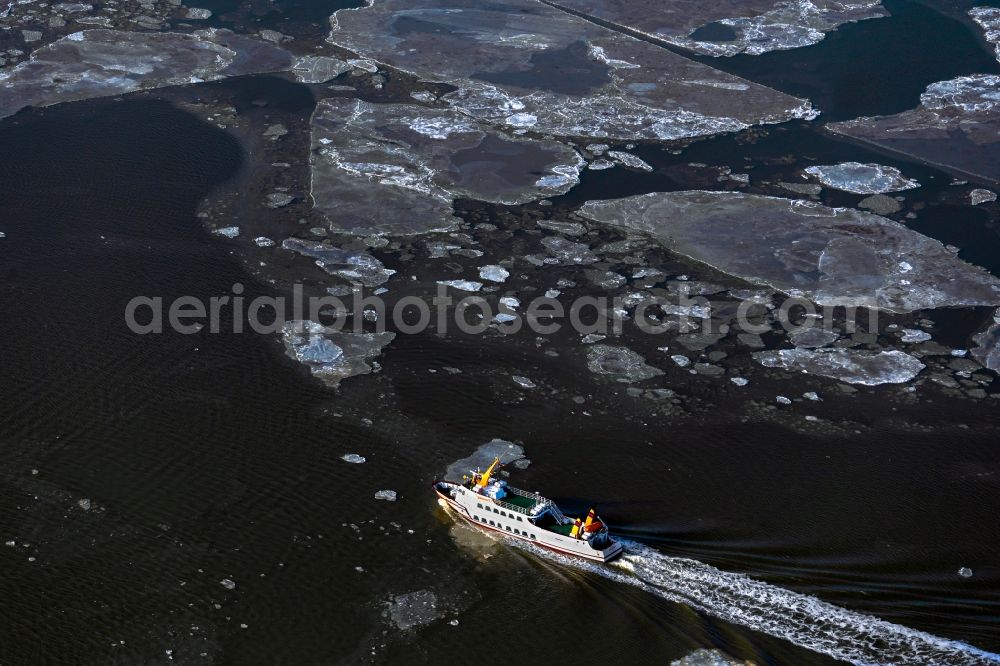 Juist from above - Winter aerial view Journey of a ferry ship Frisia X between floating ice floes in front of the North Sea island of Juist in the state of Lower Saxony, Germany