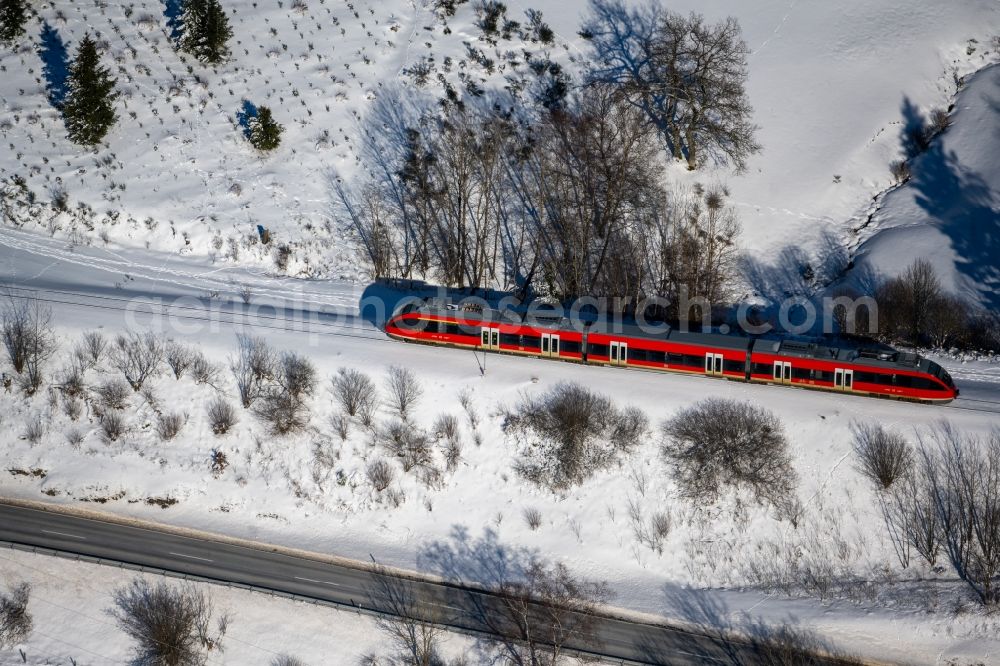 Aerial photograph Silbach - Wintry snowy driving a Regional Express - train on the track route in Silbach in the state North Rhine-Westphalia, Germany