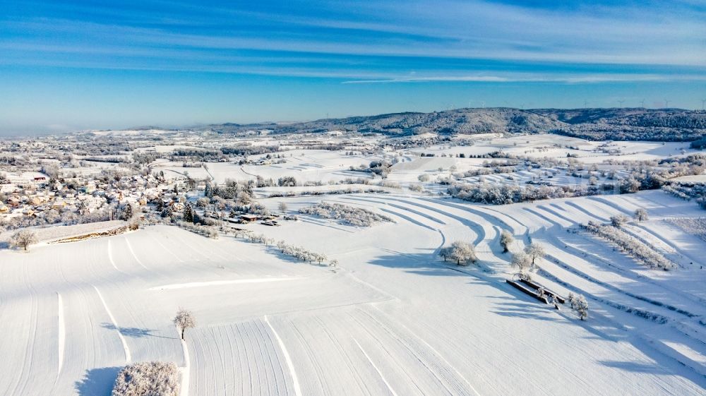 Ettenheim from the bird's eye view: Wintry snowy agricultural fields with adjacent forest and forest areas in Ettenheim in the state Baden-Wuerttemberg, Germany