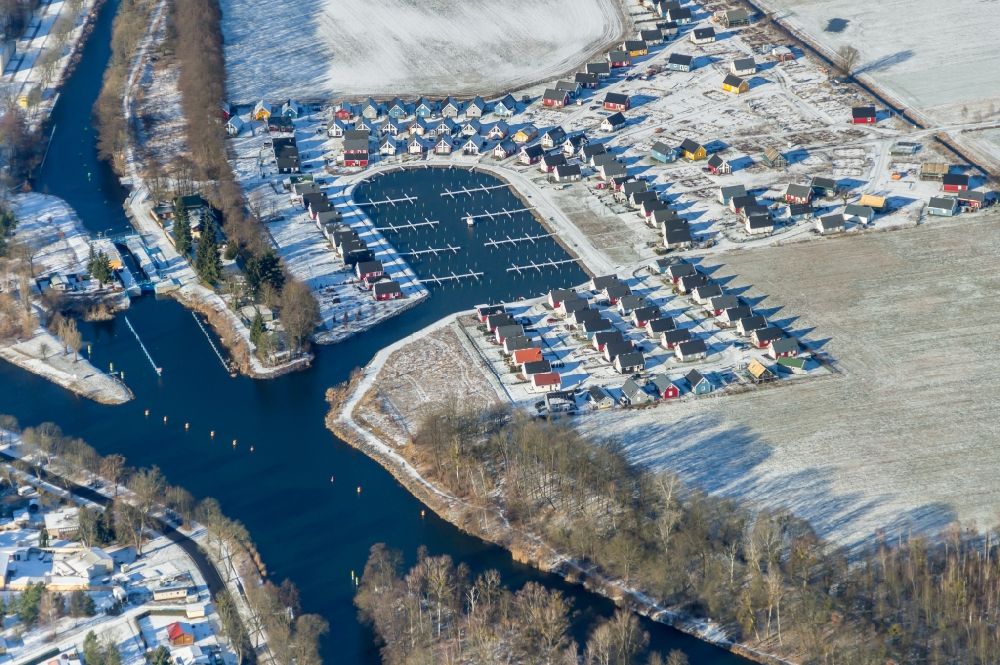 Aerial image Zerpenschleuse - Wintry snowy construction site to build new holiday apartments and to expand the holiday home complex Hafendorf Zerpenschleuse in Zerpenschleuse in the state Brandenburg, Germany