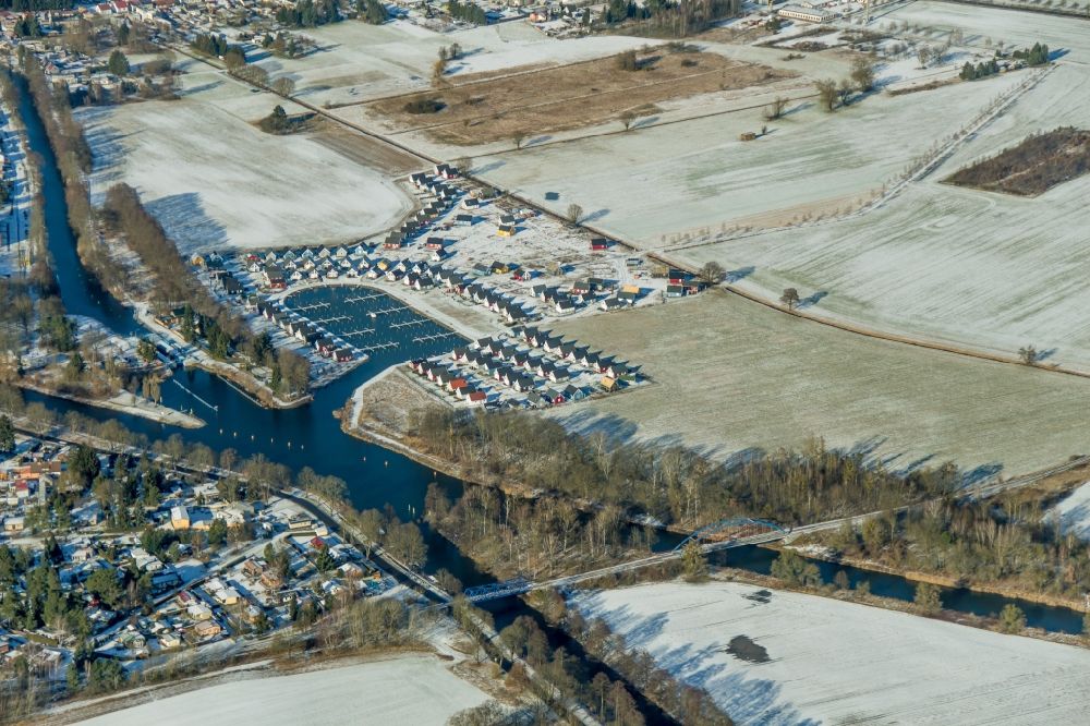 Aerial photograph Zerpenschleuse - Wintry snowy construction site to build new holiday apartments and to expand the holiday home complex Hafendorf Zerpenschleuse in Zerpenschleuse in the state Brandenburg, Germany