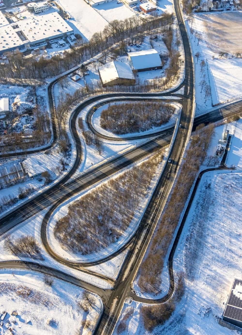 Soest from above - Wintry snowy routing and traffic lanes during the exit federal highway B475 on Opmuender Weg in Soest in the state North Rhine-Westphalia, Germany