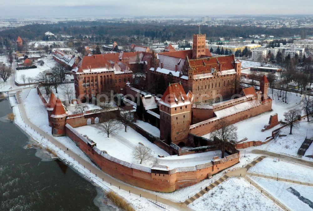 Aerial image Malbork Marienburg - Wintry snowy fortress of Ordensburg Marienburg in Malbork Marienburg in Pomorskie, Poland in winter