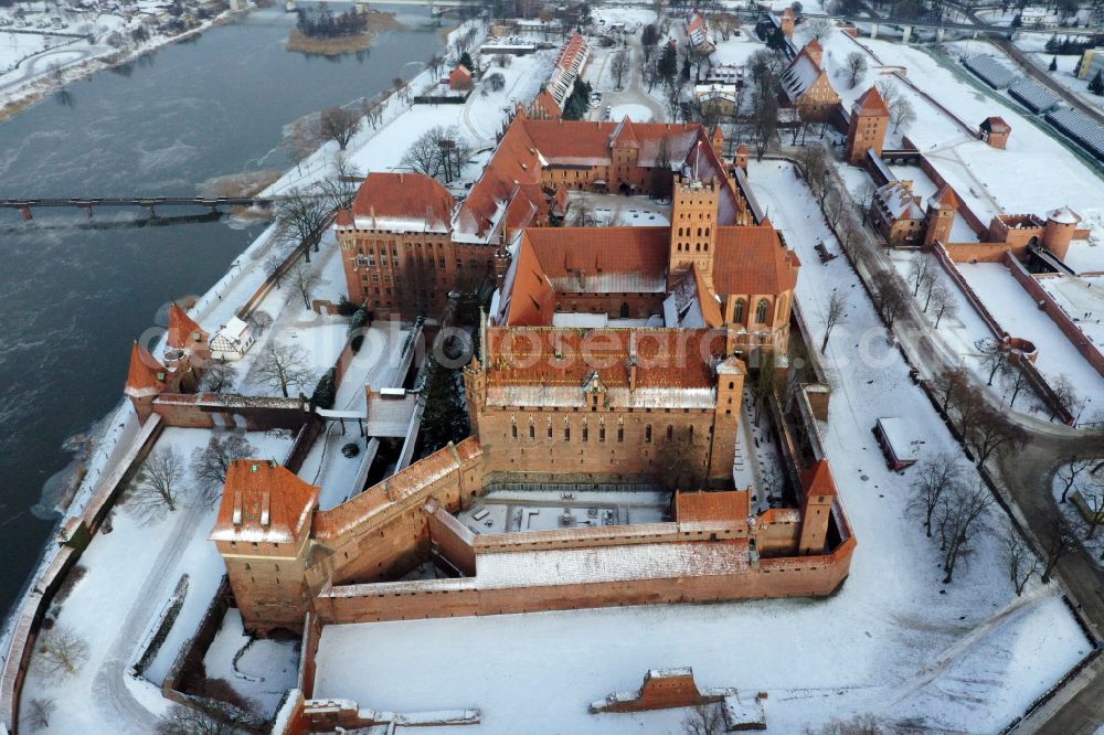 Aerial image Malbork Marienburg - Wintry snowy fortress of Ordensburg Marienburg in Malbork Marienburg in Pomorskie, Poland in winter
