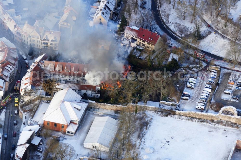 Aerial image Nordhausen - Wintry snowy extinguishing action of the fire brigade at the source of the fire and smoke formation in an apartment building Mecklenburgs Hof in Nordhausen in the state Thuringia, Germany