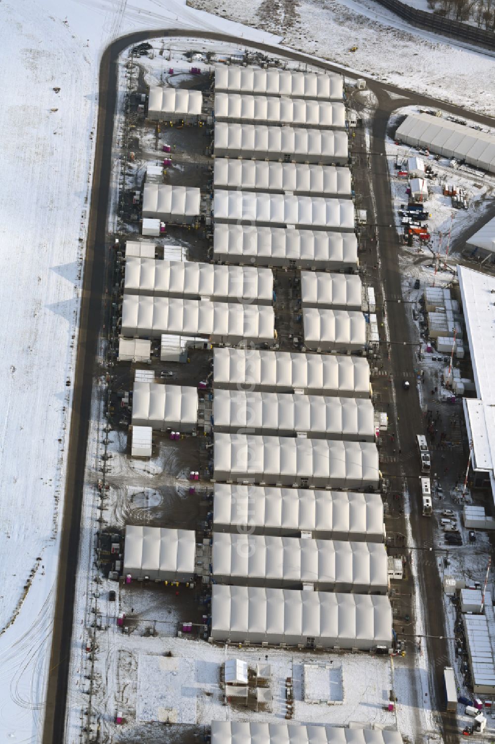 Aerial image Berlin - Wintry snowy night lights and lighting refugee home and asylum accommodation tent camp as makeshift accommodation Ukraine Arrivals Center TXL in the district of Tegel in Berlin, Germany