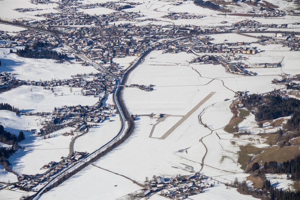 Aerial image Sankt Johann in Tirol - Wintry snowy runway with tarmac terrain of airfield St. Johann in Sankt Johann in Tirol in Tirol, Austria
