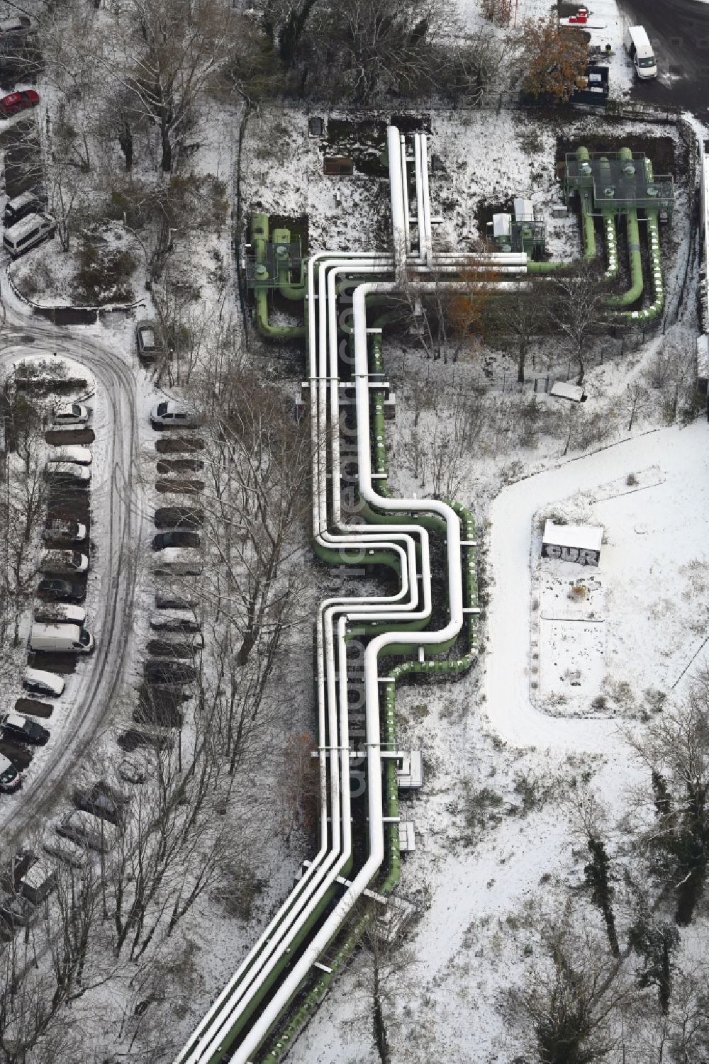 Aerial image Berlin - Wintry snowy overhead pipes for district heating supply along the Rhinstrasse in the district Lichtenberg in Berlin, Germany