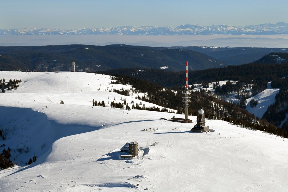 Aerial photograph Feldberg (Schwarzwald) - Wintry snowy landscape at the radio tower and transmitters on the crest of the mountain Feldberg (Schwarzwald) in the Black Forest in the state Baden-Wurttemberg. Clear view to the Swiss Alps
