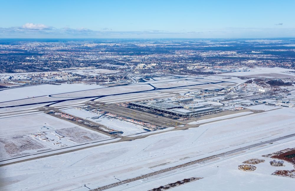 Schönefeld from above - Wintry snowy runway with hangar taxiways and terminals on the grounds of the airport BER International in Schoenefeld in the state Brandenburg, Germany