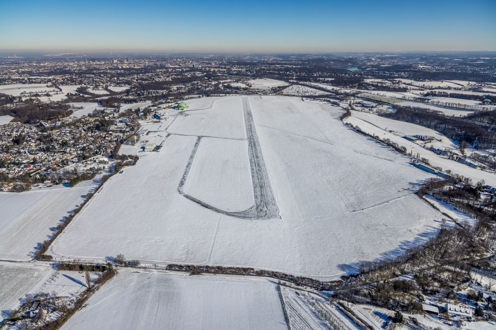 Mülheim an der Ruhr from above - Wintry snowy runway with hangar taxiways and terminals on the grounds of the airport in the district Flughafensiedlung in Muelheim on the Ruhr in the state North Rhine-Westphalia