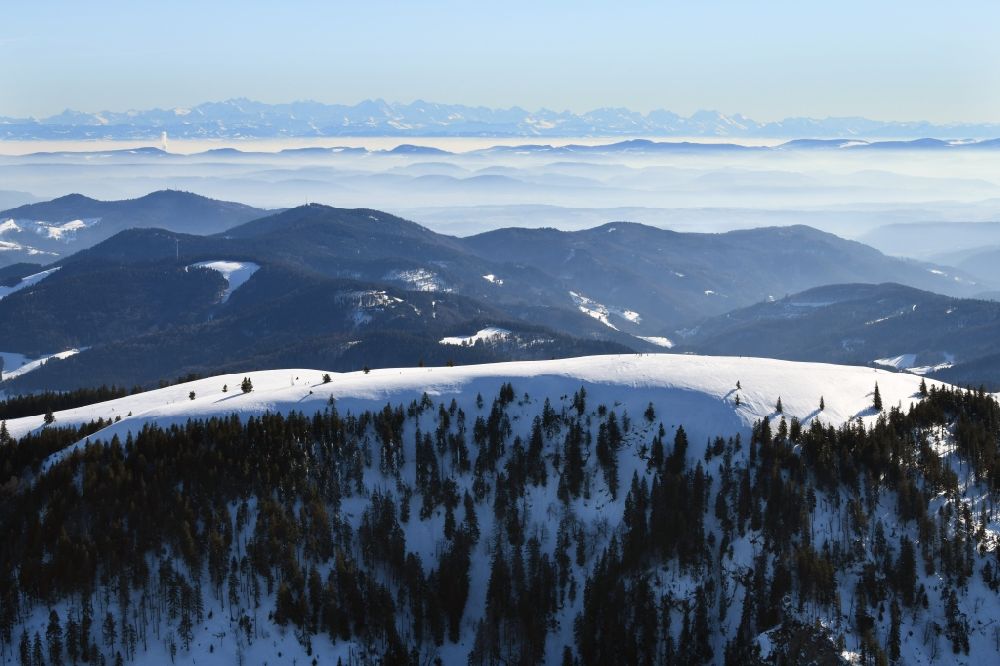 Münstertal/Schwarzwald from the bird's eye view: Wintry snowy mountainous landscape of Belchen in the Black Forest in Muenstertal/Schwarzwald in the state Baden-Wurttemberg, Germany. Looking to the south to the mountain range of the Swiss Alps