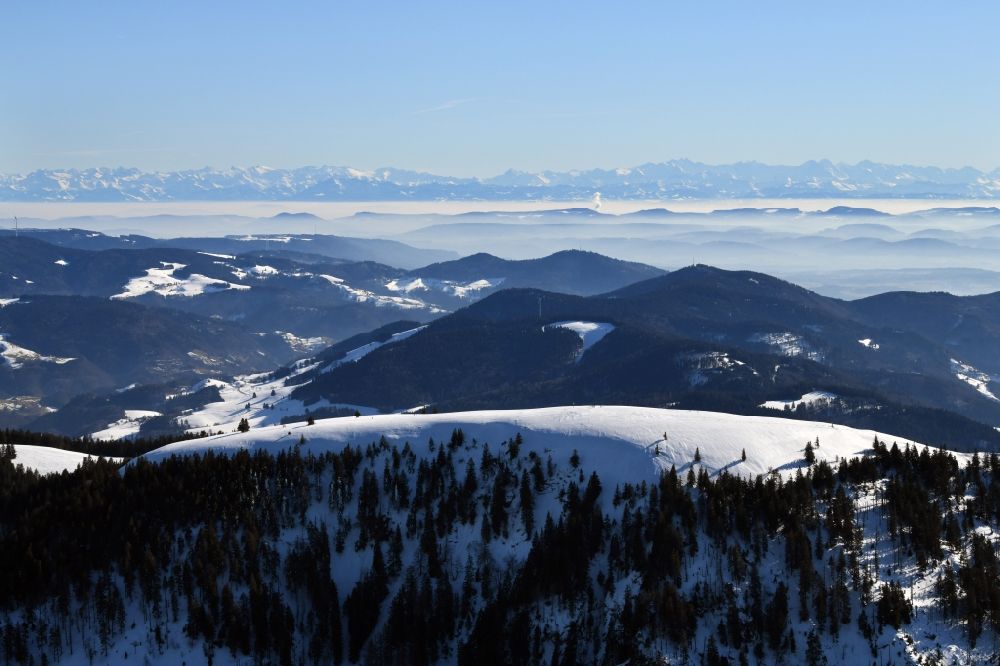 Aerial image Münstertal/Schwarzwald - Wintry snowy mountainous landscape of Belchen in the Black Forest in Muenstertal/Schwarzwald in the state Baden-Wurttemberg, Germany. Looking to the south to the mountain range of the Swiss Alps