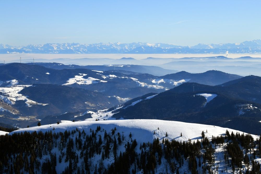 Aerial photograph Münstertal/Schwarzwald - Wintry snowy mountainous landscape of Belchen in the Black Forest in Muenstertal/Schwarzwald in the state Baden-Wurttemberg, Germany. Looking to the south to the mountain range of the Swiss Alps