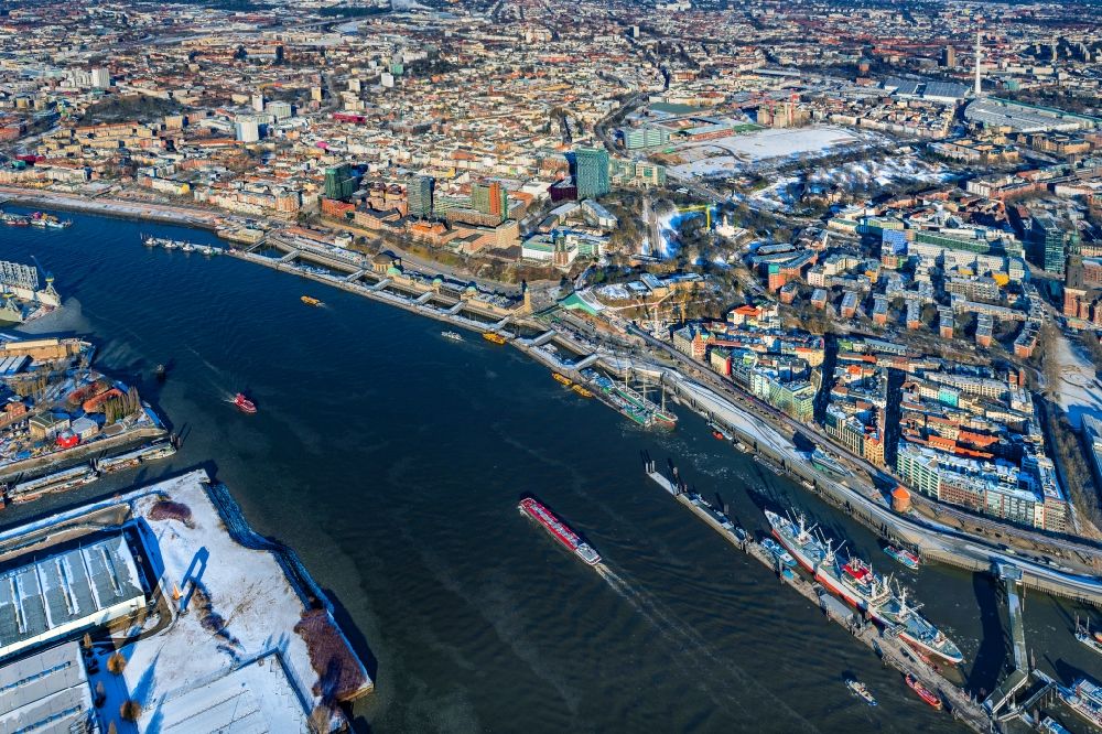 Hamburg from the bird's eye view: Wintry snowy port facilities and jetties in St.Pauli on the banks of the river course of the of the River Elbe in Hamburg, Germany