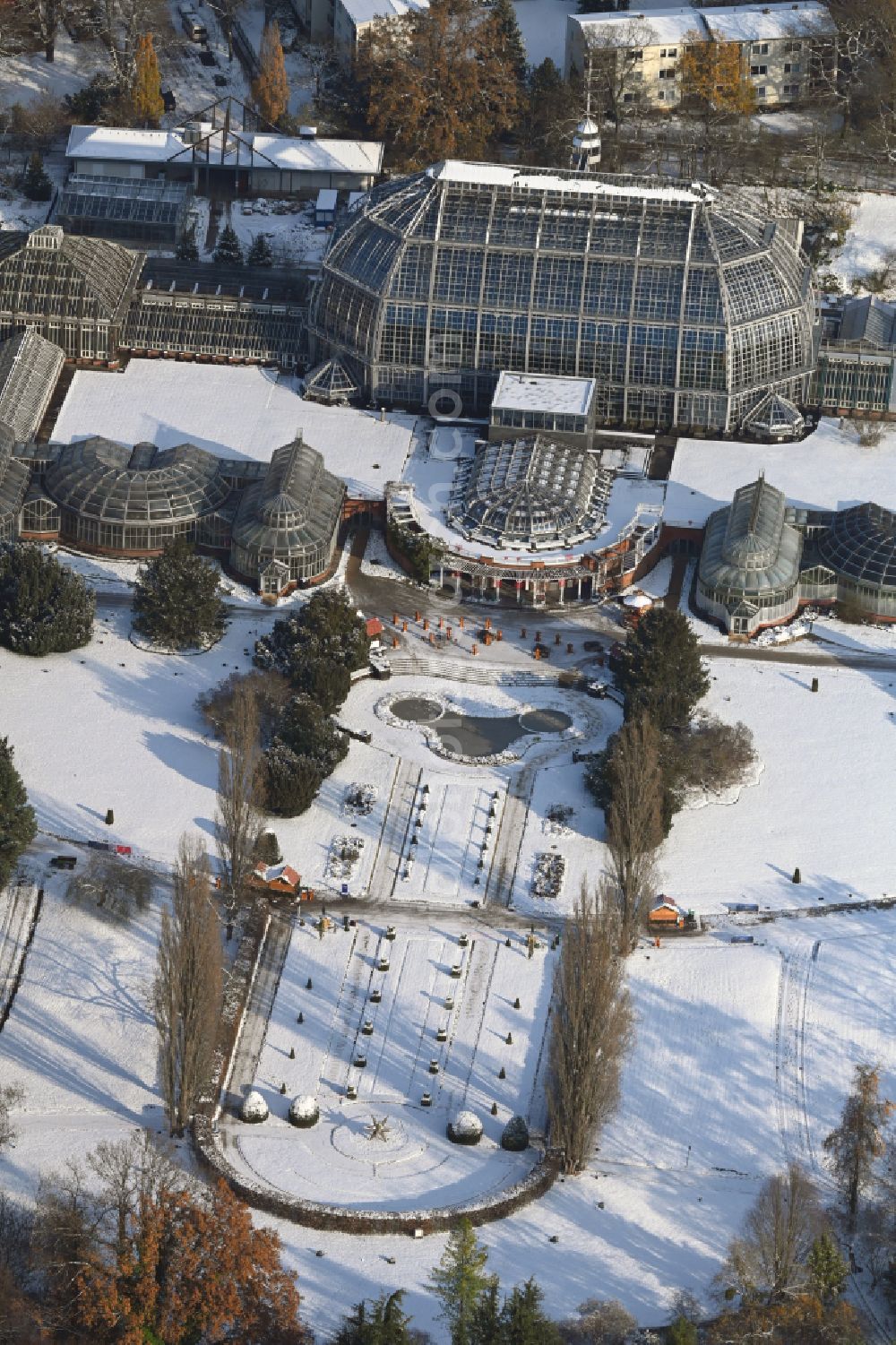 Berlin from the bird's eye view: Wintry snowy main building and greenhouse complex of the Botanical Gardens Berlin-Dahlem in Berlin. The historical glass buildings and greenhouses are dedicated to different areas. The Large Tropical House and the Victoria-House are located in the center