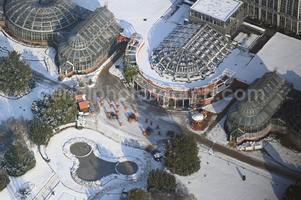 Aerial image Berlin - Wintry snowy main building and greenhouse complex of the Botanical Gardens Berlin-Dahlem in Berlin. The historical glass buildings and greenhouses are dedicated to different areas. The Large Tropical House and the Victoria-House are located in the center