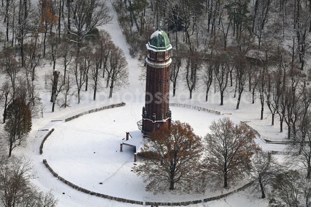 Berlin from the bird's eye view: Wintry snowy building of the industrial monument water tower in the summer garden Jungfernheide with the open-air restaurant summer garden Jungfernheide in Berlin, Germany