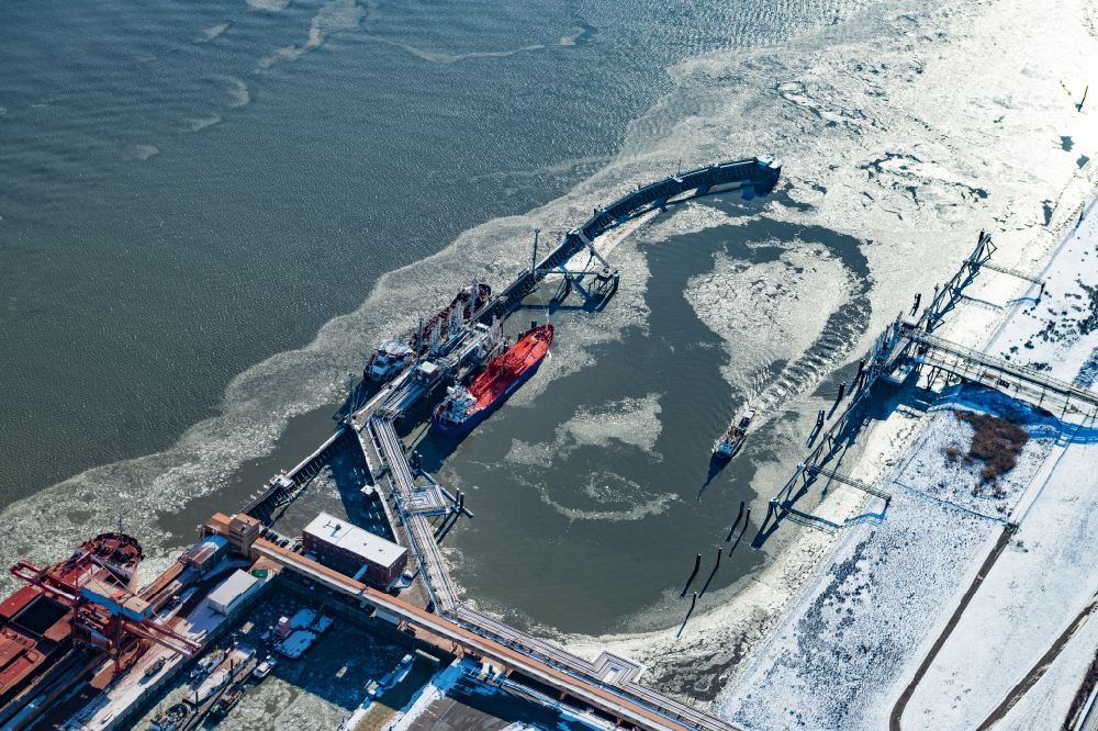 Aerial image Stade - Wintry snow-covered quays and ship moorings at the harbor basin of the Stader Seehafen in Stade an der Elbe with ice drift in the state Lower Saxony, Germany