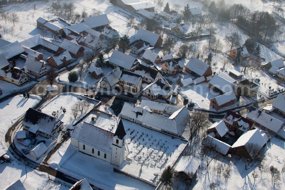 Eberbach-Seltz from above - Wintry snowy Church building in the village of in Eberbach-Seltz in Grand Est, France