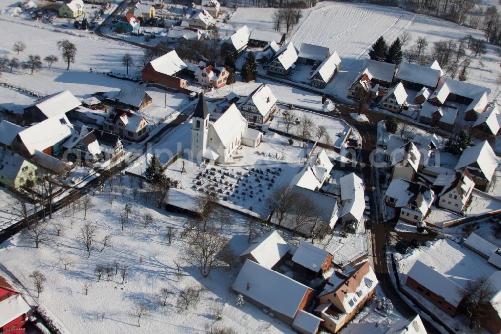 Eberbach-Seltz from the bird's eye view: Wintry snowy Church building in the village of in Eberbach-Seltz in Grand Est, France