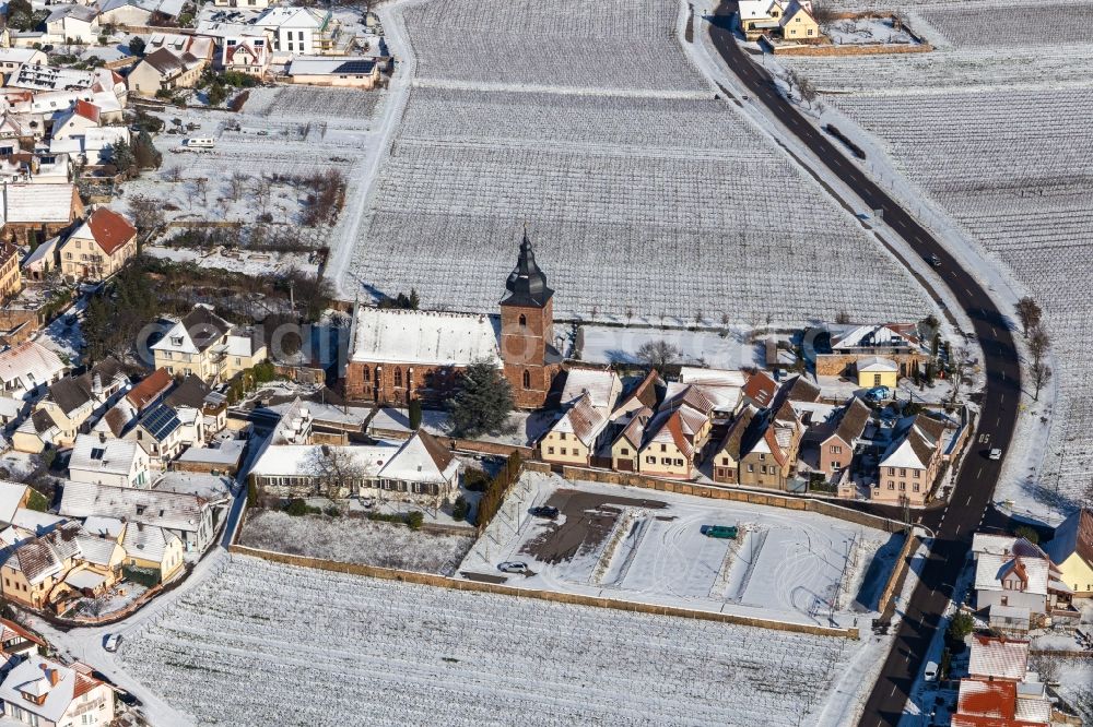 Aerial photograph Burrweiler - Wintry snowy church building of Catholic parish church of the Visitation of Mary, the wine house Vinothek Messmer, Ritterhof zur Rose in Burrweiler in the state Rhineland-Palatinate, Germany