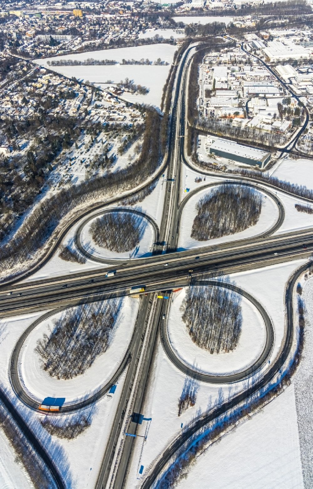 Unna from the bird's eye view: Wintry snowy traffic flow at the intersection- motorway A4 , A1 Kreuz Dortmund/Unna in form of cloverleaf in Unna in the state North Rhine-Westphalia, Germany
