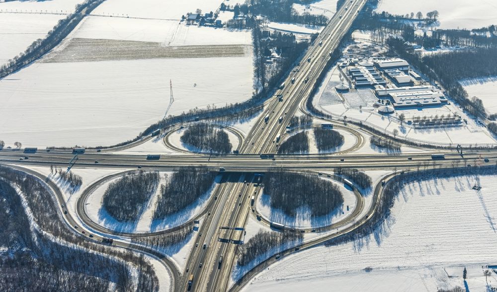 Unna from the bird's eye view: Wintry snowy traffic flow at the intersection- motorway A4 , A1 Kreuz Dortmund/Unna in form of cloverleaf in Unna in the state North Rhine-Westphalia, Germany