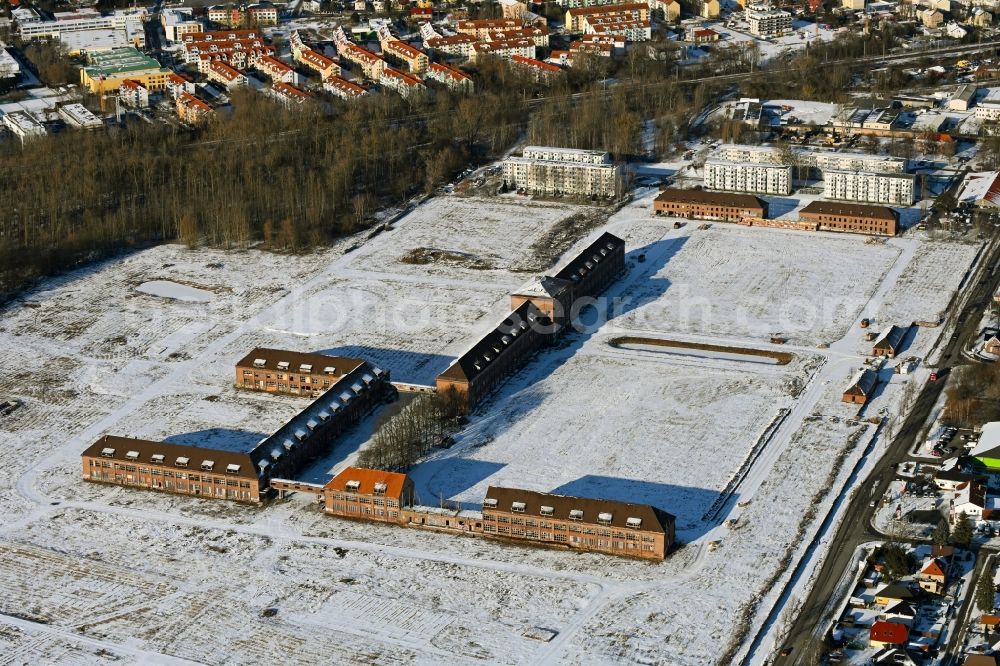 Bernau from above - Wintry snowy construction site for the renovation and reconstruction of the building complex of the former military barracks on Schwanbecker Chaussee in the district Lindow in Bernau in the state Brandenburg, Germany