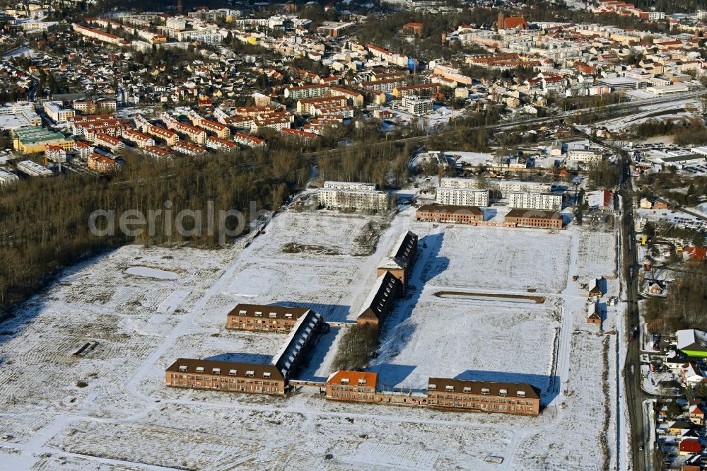 Bernau from the bird's eye view: Wintry snowy construction site for the renovation and reconstruction of the building complex of the former military barracks on Schwanbecker Chaussee in the district Lindow in Bernau in the state Brandenburg, Germany