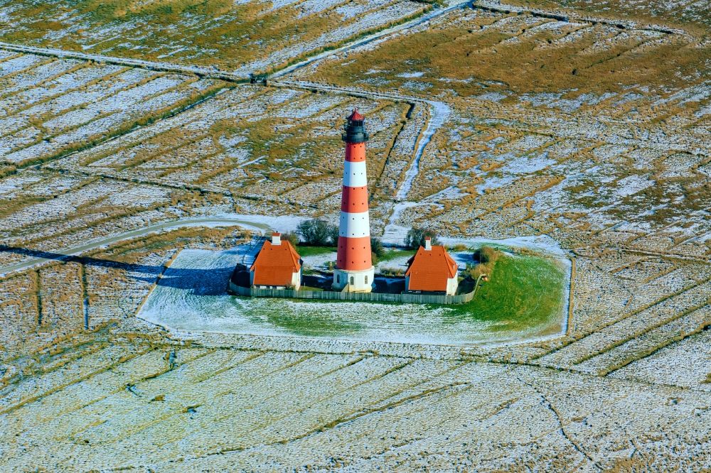 Aerial photograph Tating - Wintry snowy lighthouse as a historic seafaring character in the coastal area of North Sea in the district Hauert in Westerhever in the state Schleswig-Holstein