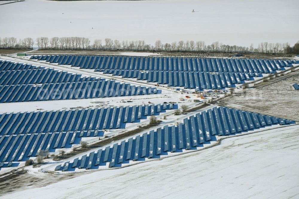 Willmersdorf from above - Wintry snowy construction site and assembly work for solar park and solar power plant Solarpark Weesow-Willmersdorf in Willmersdorf in the state Brandenburg, Germany