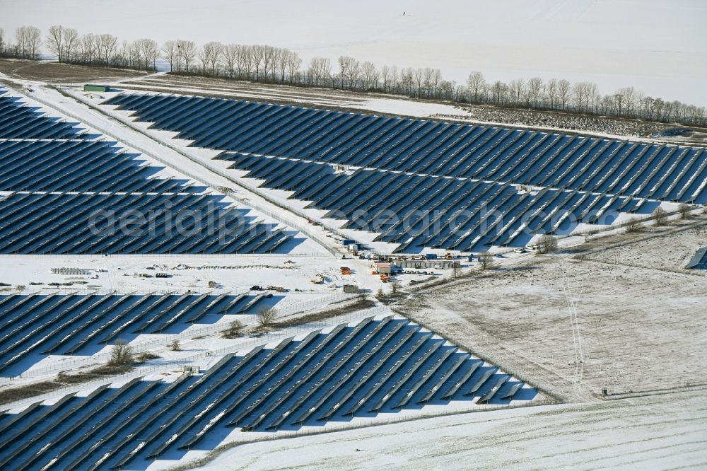 Willmersdorf from the bird's eye view: Wintry snowy construction site and assembly work for solar park and solar power plant Solarpark Weesow-Willmersdorf in Willmersdorf in the state Brandenburg, Germany