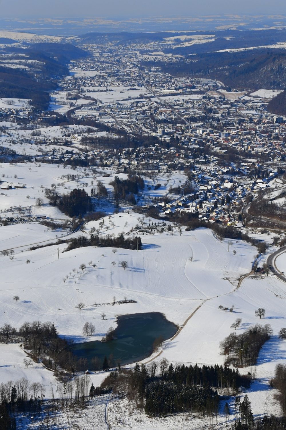 Aerial image Schopfheim - Wintry snowy landscape at Schopfheim in Baden-Wuerttemberg with the nature reserve Eichener See. The lake in the karst appears only after heavy rainfall and sometimes remains for years disappeared