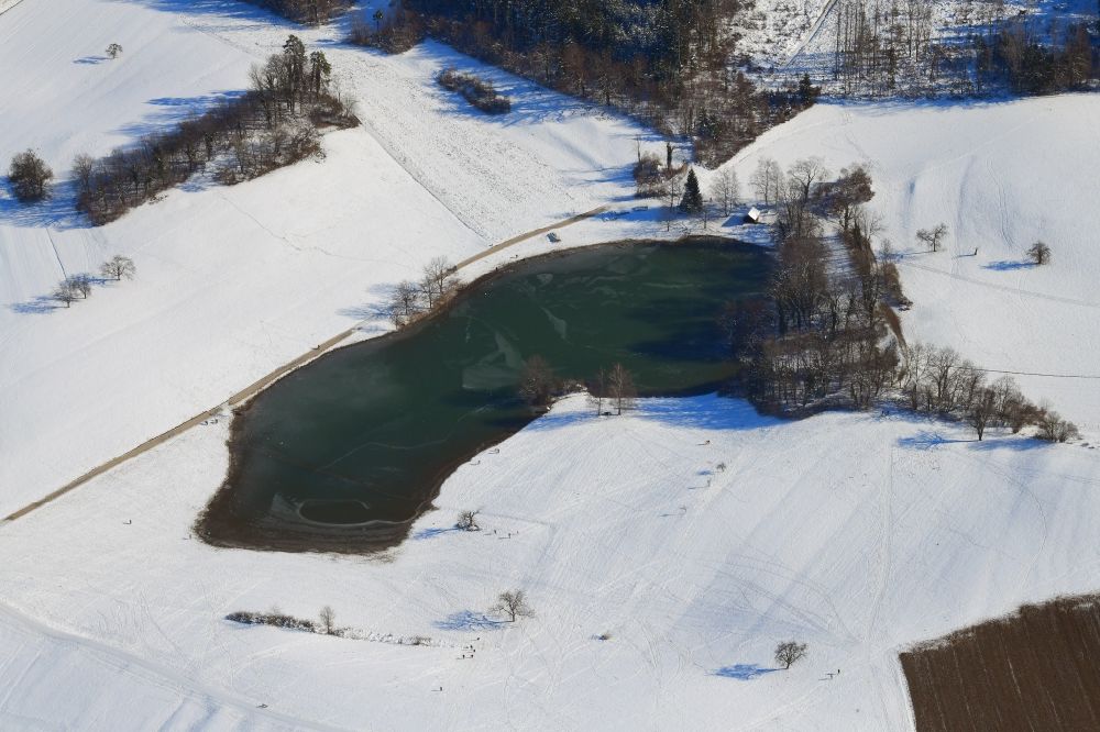 Aerial image Schopfheim - Wintry snowy landscape at Schopfheim in Baden-Wuerttemberg with the nature reserve Eichener See. The lake in the karst appears only after heavy rainfall and sometimes remains for years disappeared