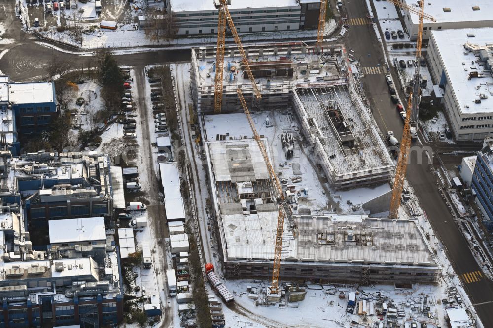 Berlin from the bird's eye view: Wintry snowy construction site to build a new office and commercial building INK Berlin - Inspire Neukoelln on Ballinstrasse - Woermannkehre in the district Neukoelln in Berlin, Germany