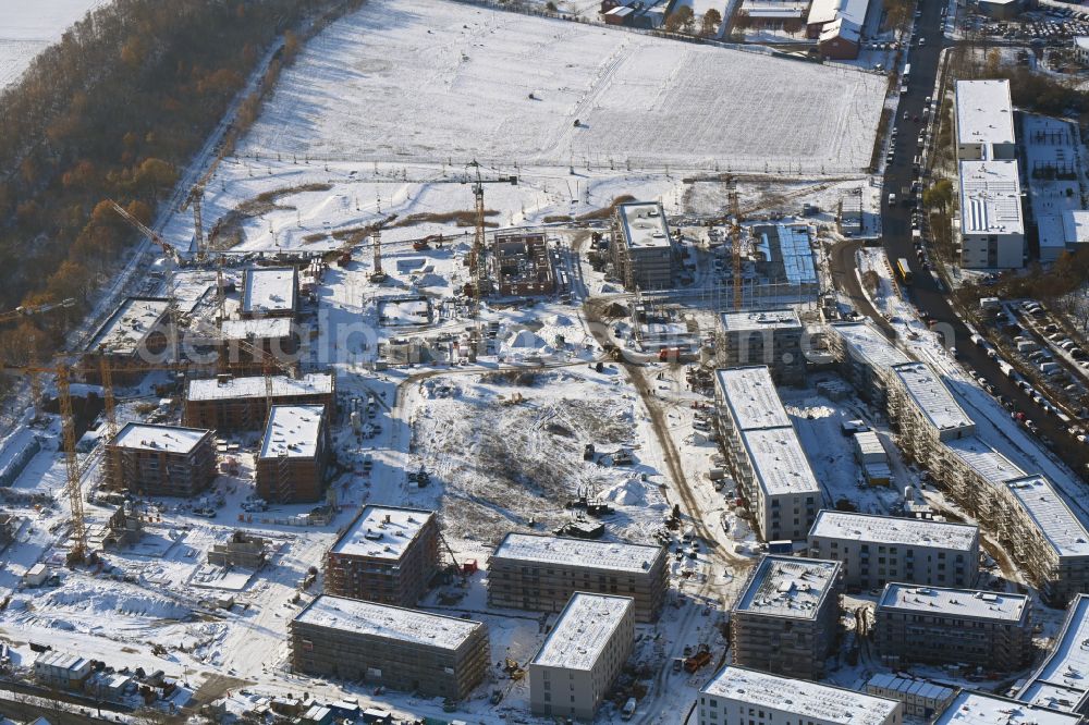 Berlin from the bird's eye view: Wintry snowy construction site to build a new multi-family residential complex Buckower Felder on street Gerlinger Strasse in the district Buckow in Berlin, Germany