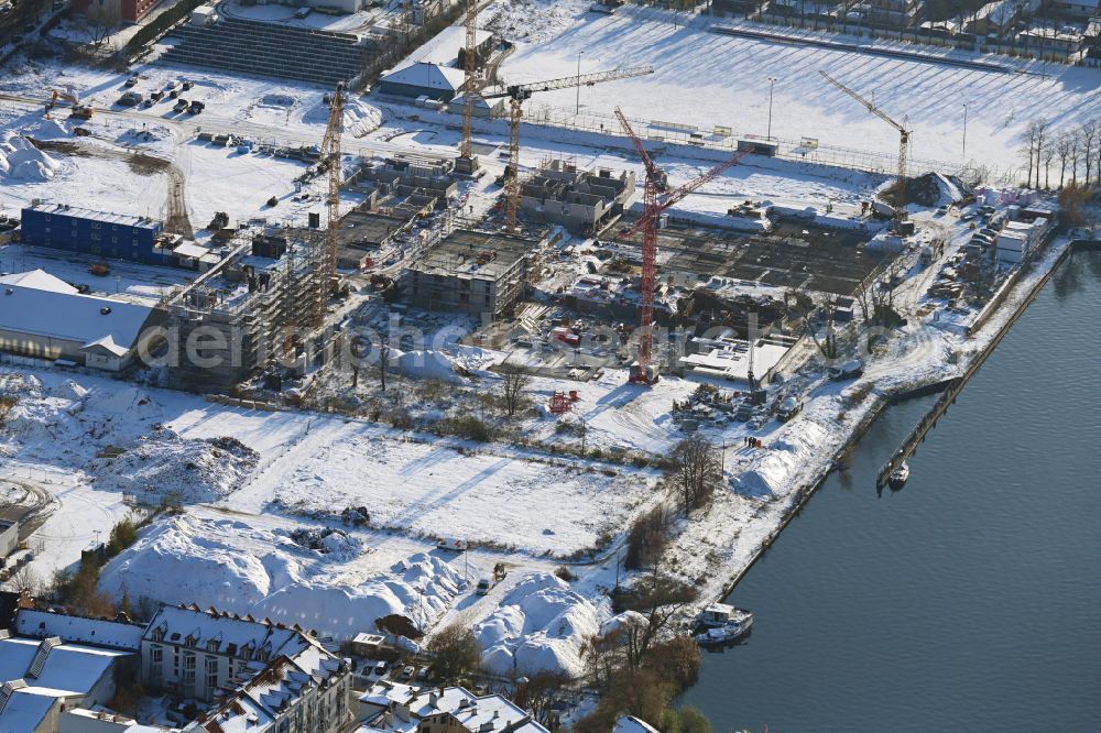 Berlin from above - Wintry snowy construction site to build a new multi-family residential complex on street Wendenschlossstrasse in the district Koepenick in Berlin, Germany