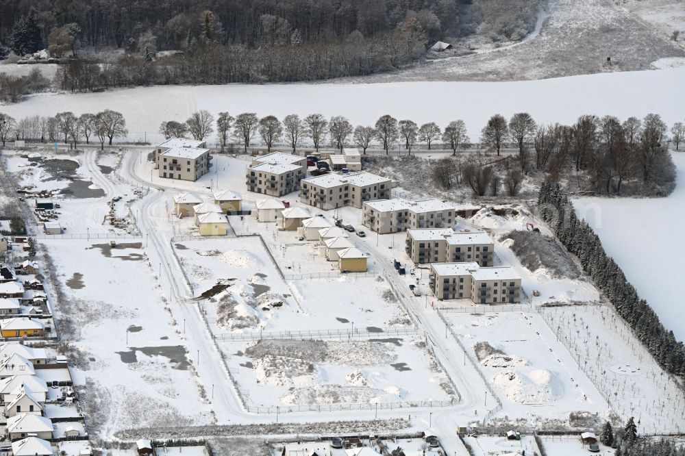 Biesenthal from the bird's eye view: Wintry snowy construction site to build a new multi-family residential complex Naturquartier in Biesenthal in the state Brandenburg, Germany