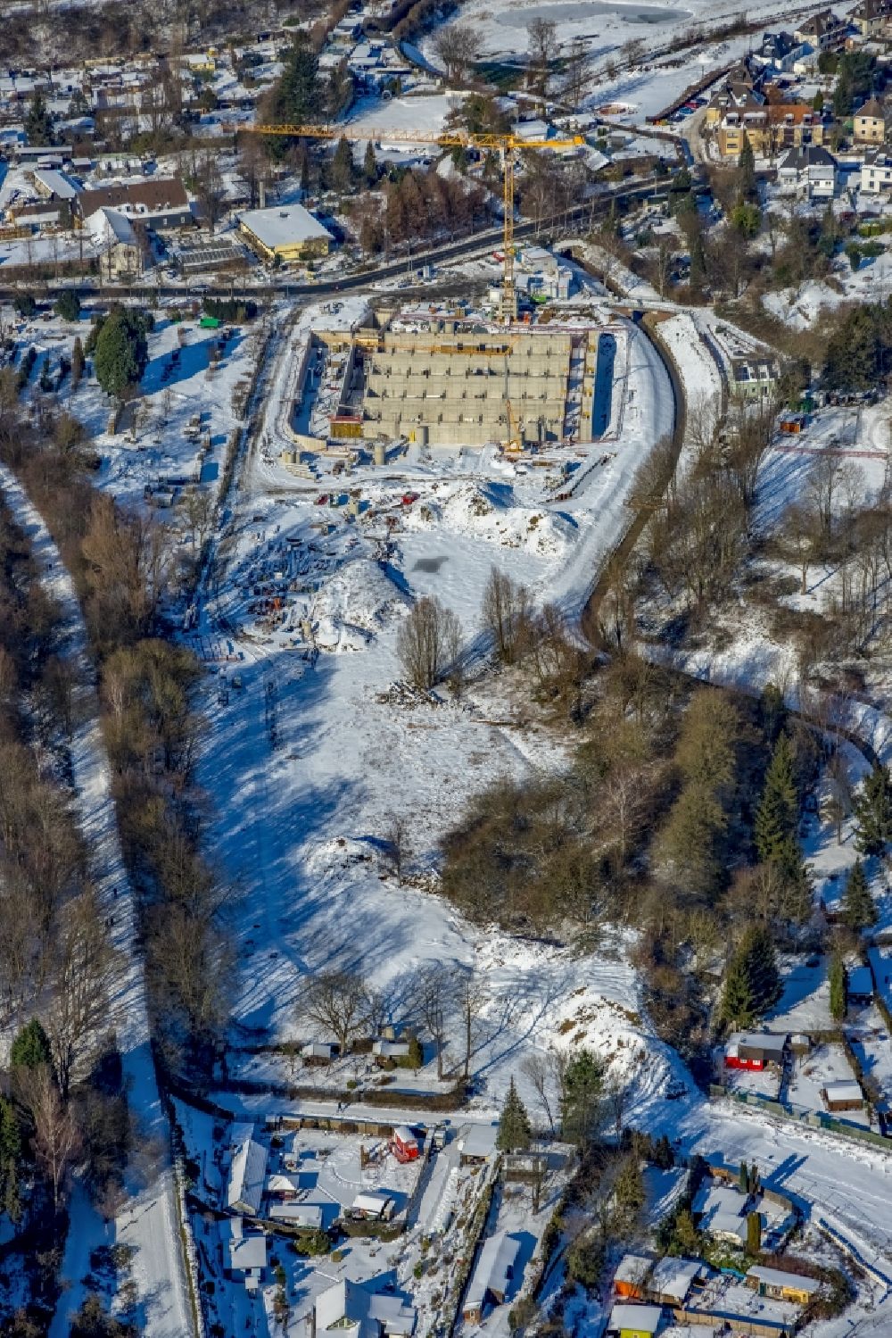 Aerial image Mülheim an der Ruhr - Wintry snowy construction site for the new construction of the retention basin and water storage - rain overflow basin (RUeB) on Frohnhauser Weg in the district Frohnhausen in Muelheim on the Ruhr at Ruhrgebiet in the state North Rhine-Westphalia, Germany