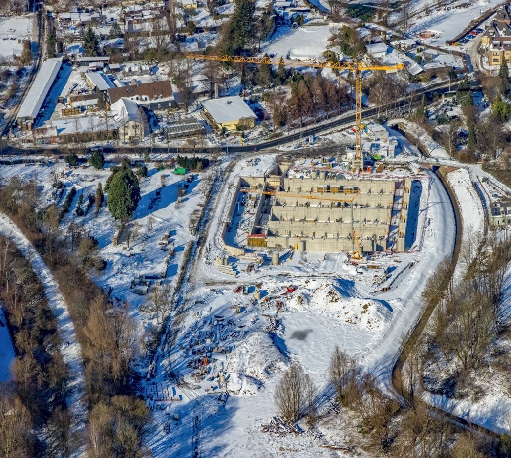 Aerial photograph Mülheim an der Ruhr - Wintry snowy construction site for the new construction of the retention basin and water storage - rain overflow basin (RUeB) on Frohnhauser Weg in the district Frohnhausen in Muelheim on the Ruhr at Ruhrgebiet in the state North Rhine-Westphalia, Germany
