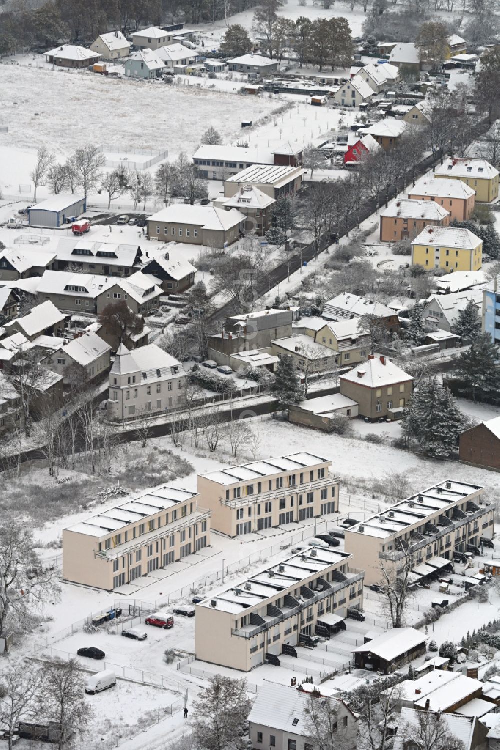 Aerial image Werneuchen - Wintry snowy construction site of a new residential area of the terraced housing estate Landsberger Strasse corner Wegendorfer Strasse in Werneuchen in the state Brandenburg, Germany