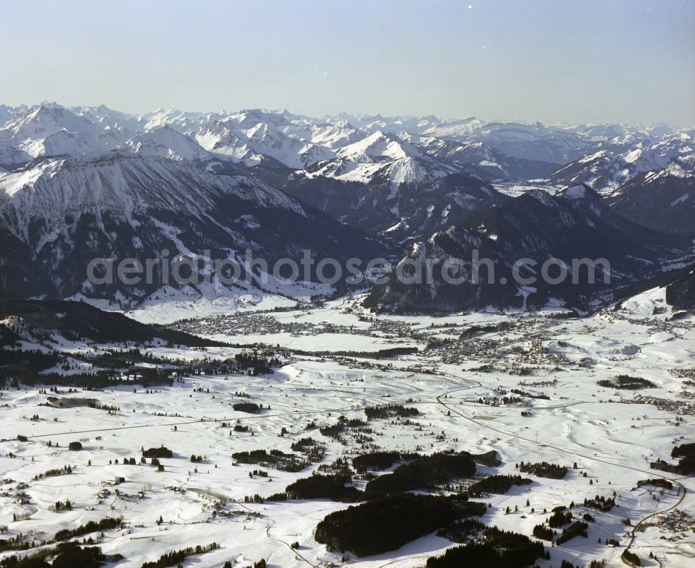 Aerial photograph Pfronten - Wintry snowy location view of the streets and houses of residential areas in the valley landscape surrounded by mountains in Pfronten in the state Bavaria, Germany