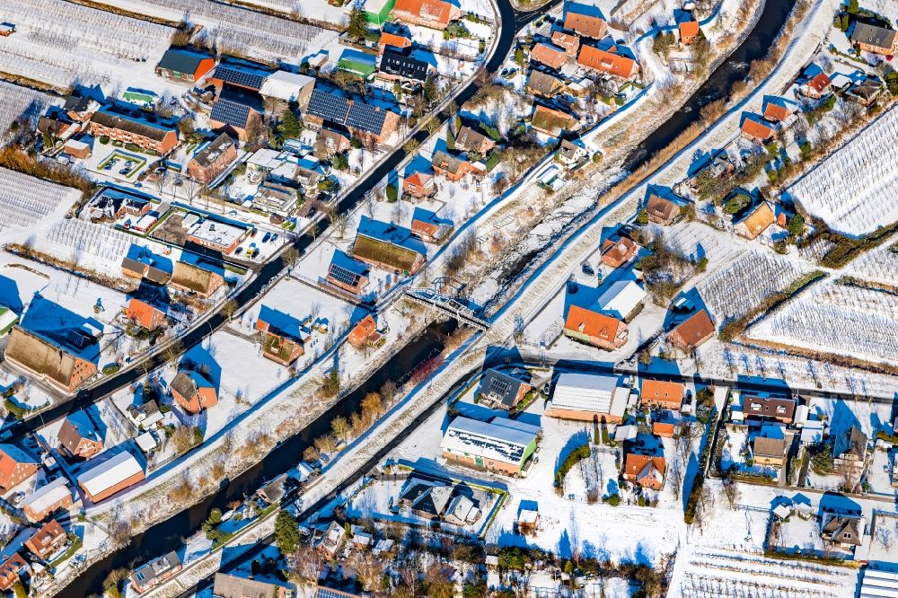 Aerial photograph Steinkirchen - Wintry snowy village on the banks of the area Luehe - river course in Steinkirchen in the state Lower Saxony, Germany