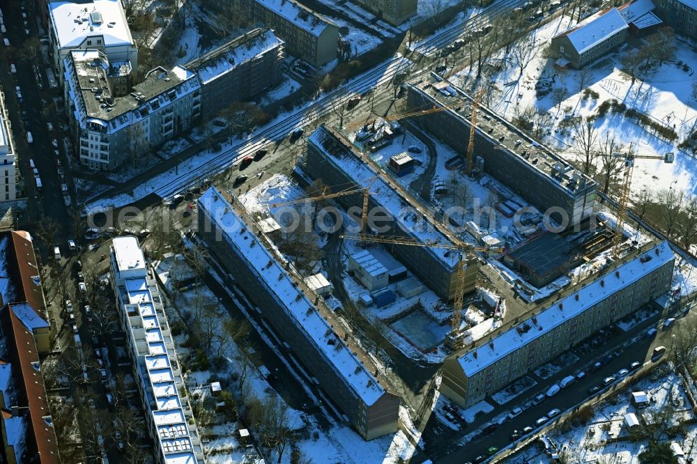 Berlin from above - Wintry snowy refurbishment and modernization of a terraced apartment complex between Wolfshagener Strasse and Stiftsweg in the district Pankow in Berlin, Germany