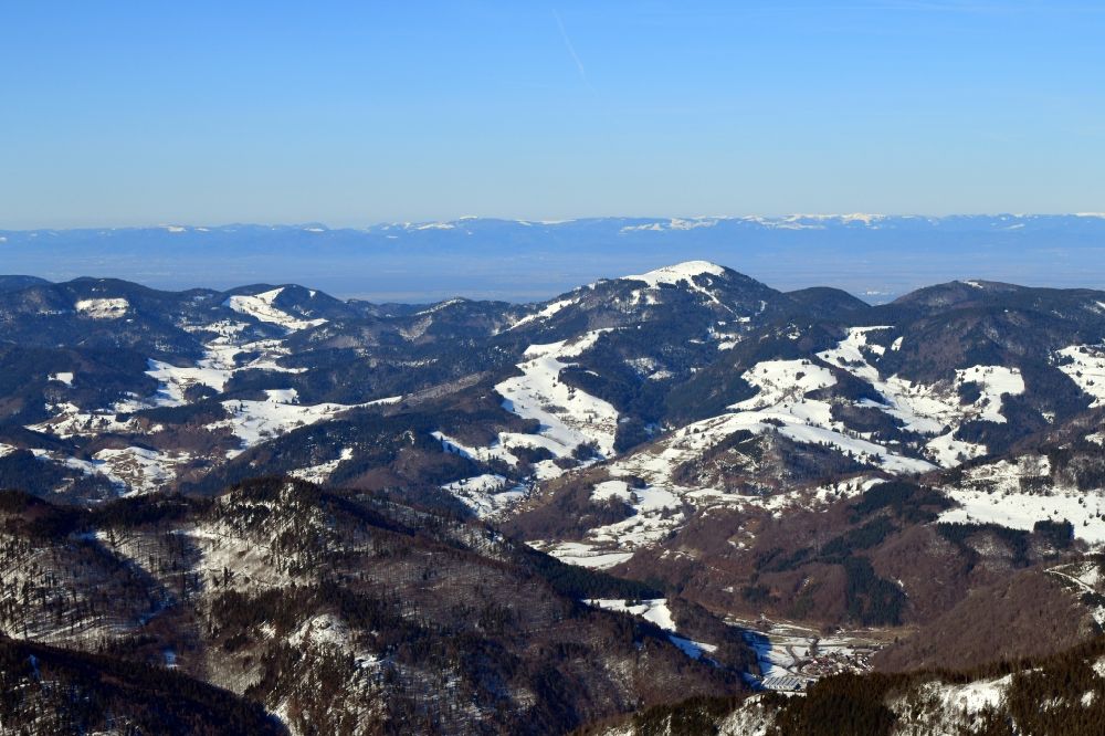 Aerial photograph Schönenberg - Wintry snowy mountains in the Black Forest at Schoenenberg in the state Baden-Wurttemberg, Germany. Looking over the bold summit of Belchen to the mountain range of the Vosges in France