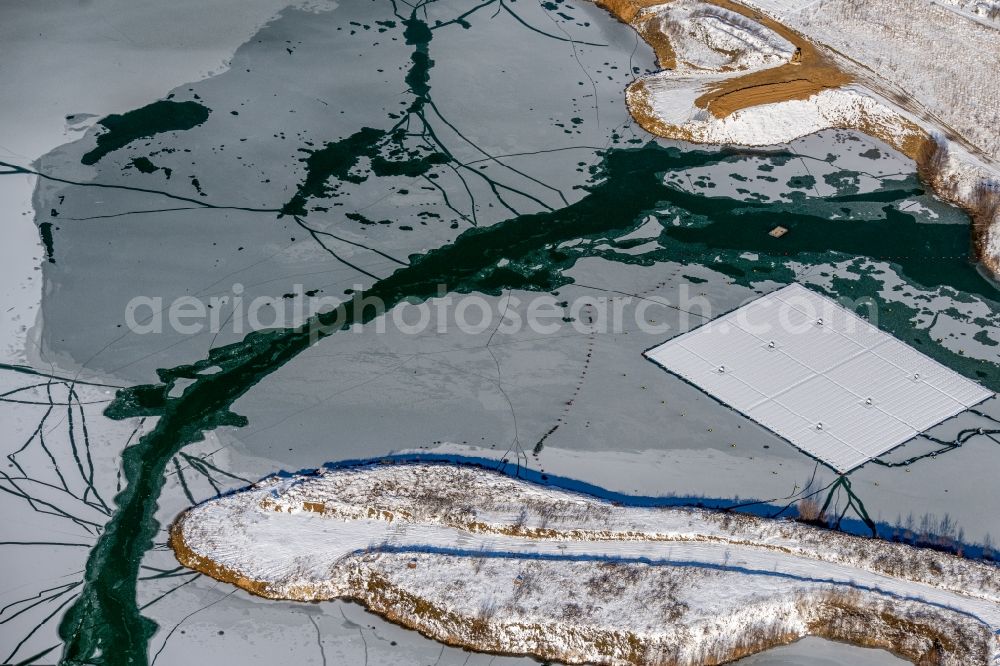 Aerial image Dettelbach - Wintry snowy floating solar power plant and panels of photovoltaic systems on the surface of the water on Dettelbacher Baggersee in Dettelbach in the state Bavaria, Germany