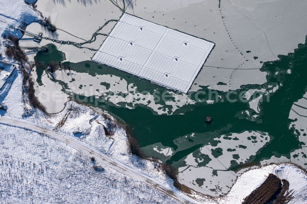 Aerial image Dettelbach - Wintry snowy floating solar power plant and panels of photovoltaic systems on the surface of the water on Dettelbacher Baggersee in Dettelbach in the state Bavaria, Germany