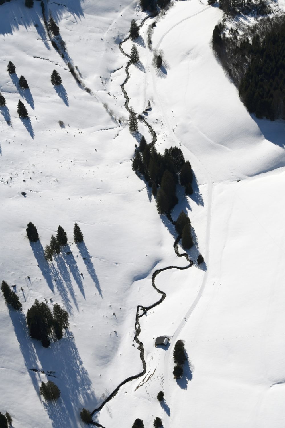 Aerial photograph Todtnau - Wintry snowy meandering, serpentine curved creek Holzschlagbach in the district Muggenbrunn in the Black Forest in Todtnau in the state Baden-Wurttemberg, Germany