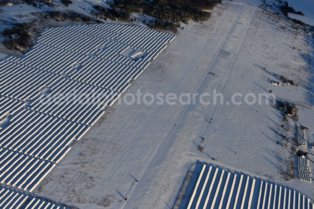 Werneuchen from above - Wintry snowy Solar power plant and photovoltaic systems on the airfield in Werneuchen in the state Brandenburg